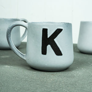 Bild in Slideshow öffnen, Caneca Keramik-Becher (hellgrau mit Buchstaben)
